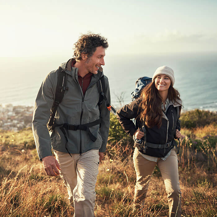 man and woman hiking on hillside