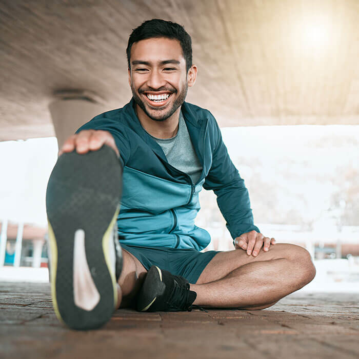 man smiling and stretching for a run