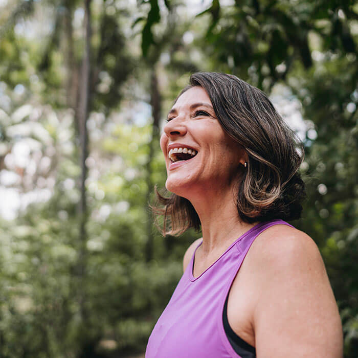 woman with mouth open smiling in the woods