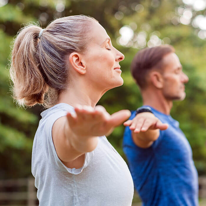 woman and man with arms stretched out and eyes closed