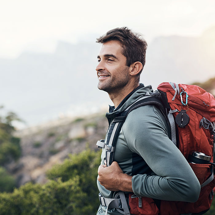 smiling man hiking on cloudy mountainside