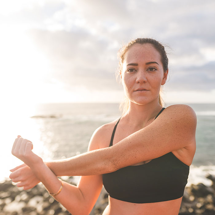 woman stretching arms near the beach