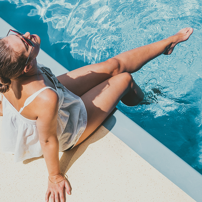 Woman sitting by the pool free of varicose veins