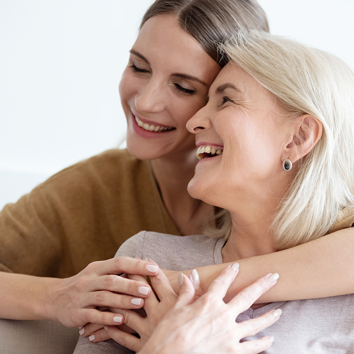 Adult daughter hugging her senior mother